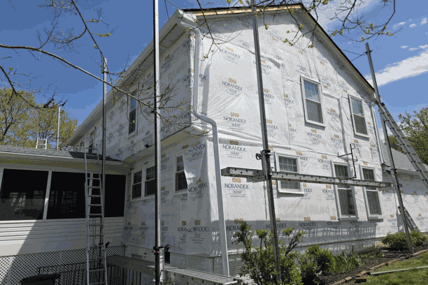 United Developers crew installing fiber-cement siding over housewrap on a DMV home